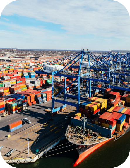 Aerial view of a busy port with cranes loading and unloading colorful shipping containers